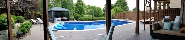 outdoor pool featuring fence, an outdoor hangout area, and a patio