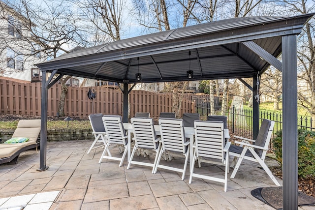 view of patio / terrace with outdoor dining space, fence, and a gazebo