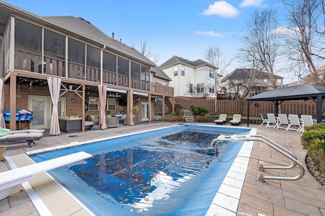 view of swimming pool with a patio, fence, a sunroom, a gazebo, and a fenced in pool