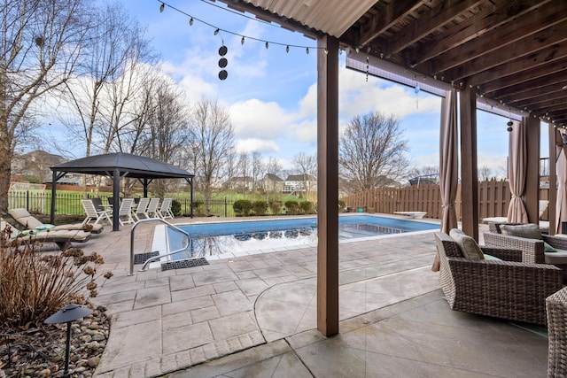 view of pool featuring a fenced backyard, a fenced in pool, a patio, and a gazebo