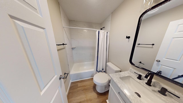 full bathroom featuring toilet, shower / bath combination with curtain, wood-type flooring, a textured ceiling, and vanity