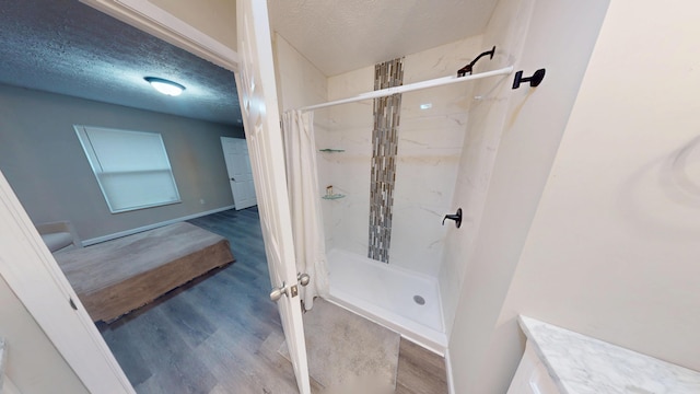 bathroom featuring a shower with curtain, vanity, hardwood / wood-style floors, and a textured ceiling