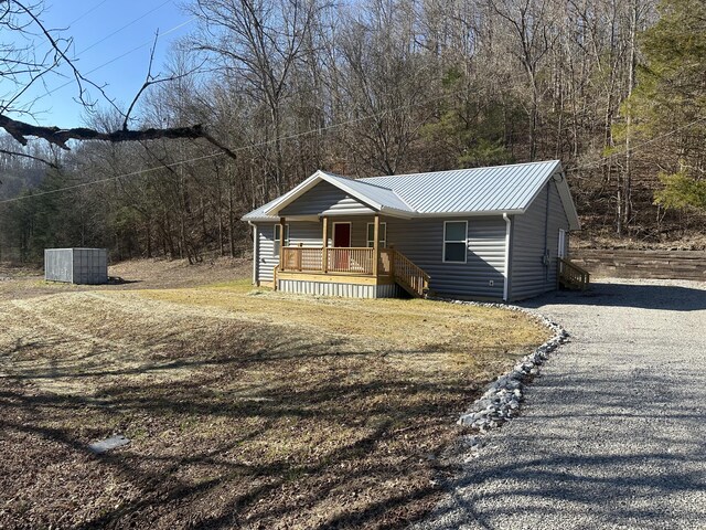 view of side of property featuring a porch and a yard