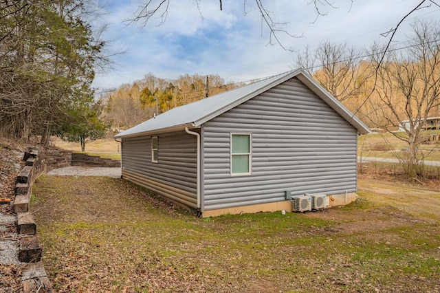 view of home's exterior featuring ac unit and a yard