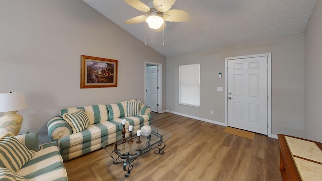 living room featuring ceiling fan, light hardwood / wood-style floors, and vaulted ceiling