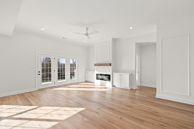 unfurnished living room with ceiling fan, ornamental molding, and light hardwood / wood-style flooring