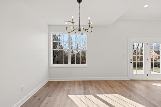 unfurnished dining area featuring a notable chandelier and light hardwood / wood-style floors