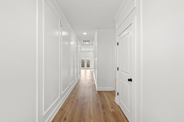 hallway featuring crown molding and light wood-type flooring