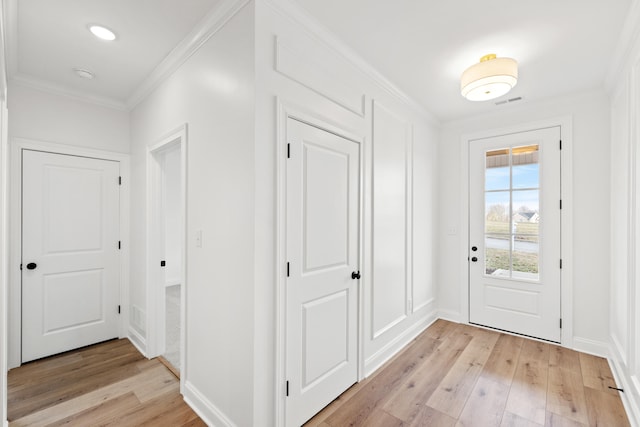 doorway featuring crown molding and light hardwood / wood-style floors