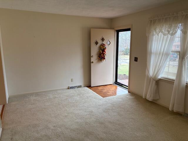 unfurnished room featuring light carpet