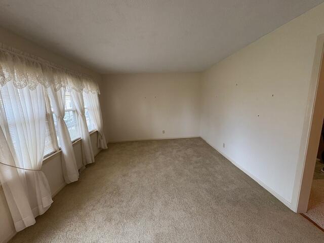 carpeted empty room with a textured ceiling