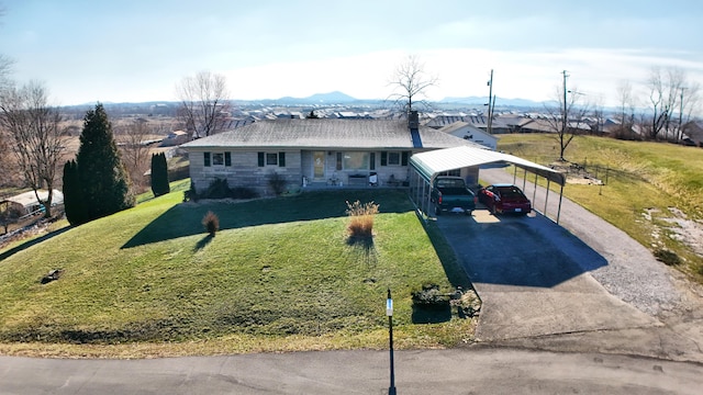 single story home featuring a front yard, a carport, and covered porch