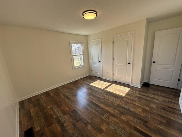 unfurnished bedroom featuring dark hardwood / wood-style floors and a textured ceiling