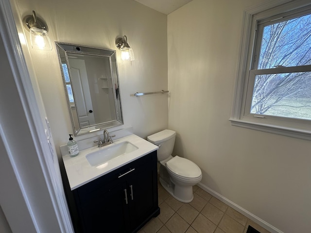 bathroom featuring vanity, plenty of natural light, tile patterned floors, and toilet