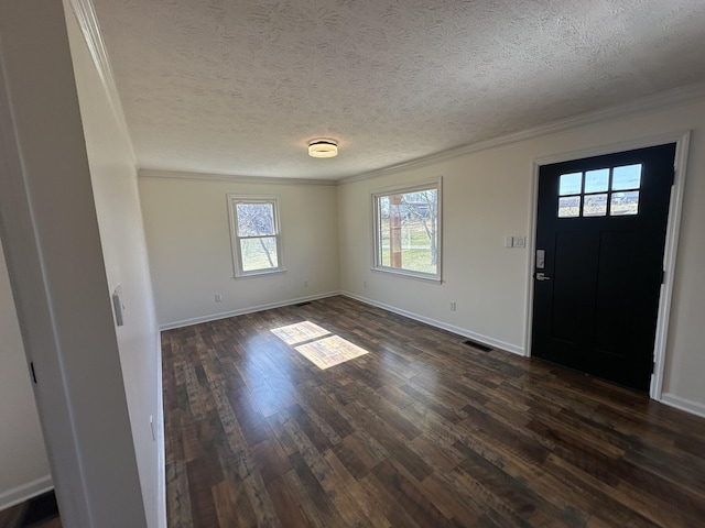 foyer entrance with ornamental molding, dark hardwood / wood-style floors, and a textured ceiling