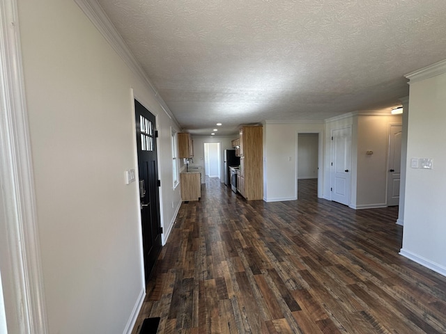 unfurnished living room with dark hardwood / wood-style flooring, ornamental molding, and a textured ceiling