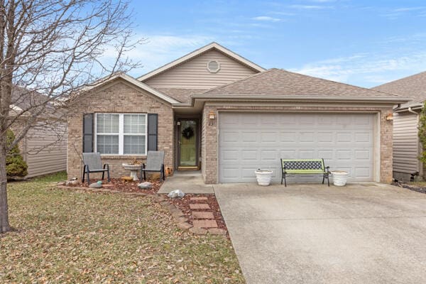 single story home featuring a garage and a front yard