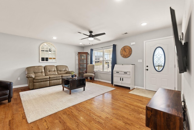 living room with ceiling fan and light hardwood / wood-style flooring