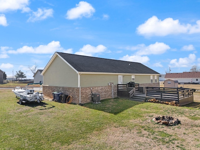 view of side of property with a wooden deck, central AC unit, and a yard