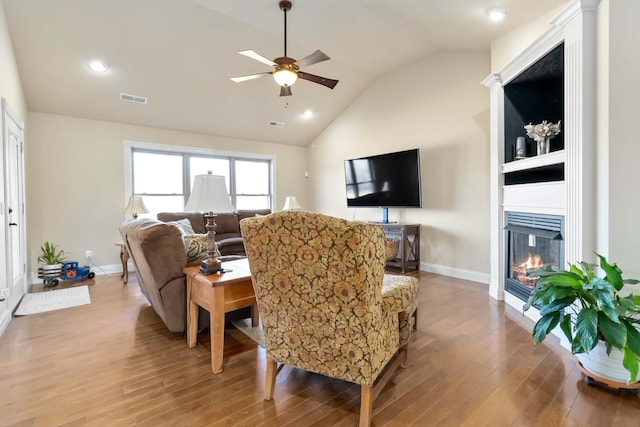 living room with vaulted ceiling, ceiling fan, and light hardwood / wood-style floors