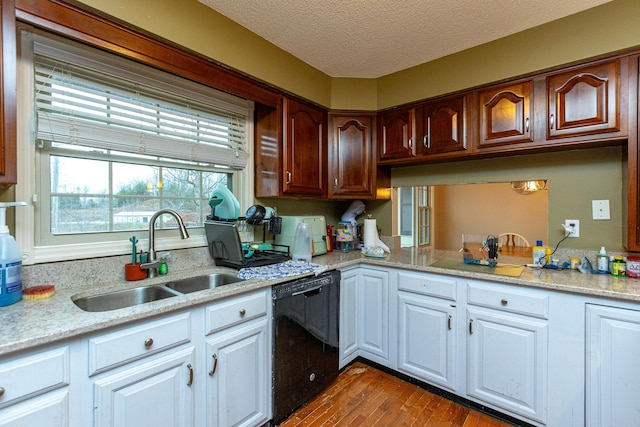 kitchen featuring dishwasher, a textured ceiling, a sink, and white cabinetry