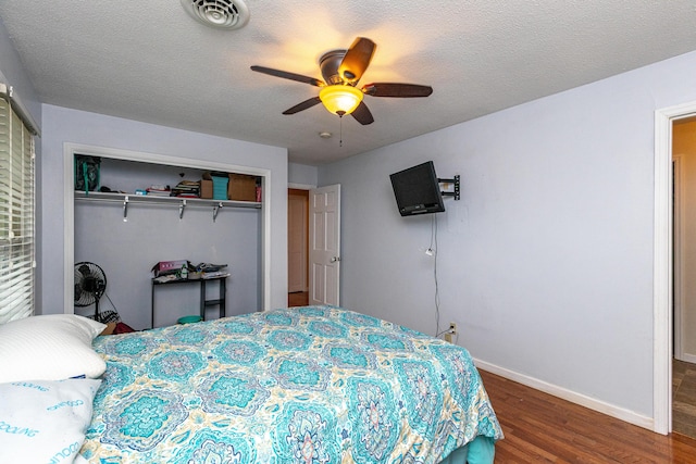 bedroom with baseboards, visible vents, a closet, and wood finished floors