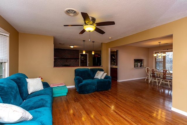 living room with a textured ceiling, wood finished floors, and visible vents