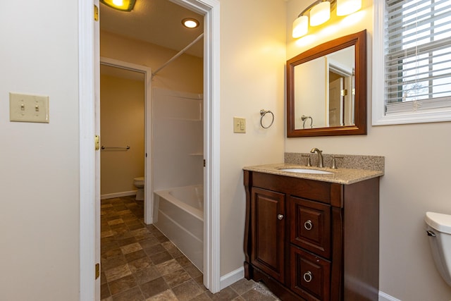 bathroom featuring baseboards, vanity, and toilet