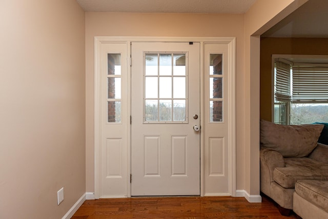 doorway to outside featuring dark wood-style floors and baseboards