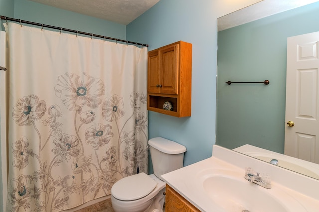 bathroom with toilet, curtained shower, a textured ceiling, and vanity