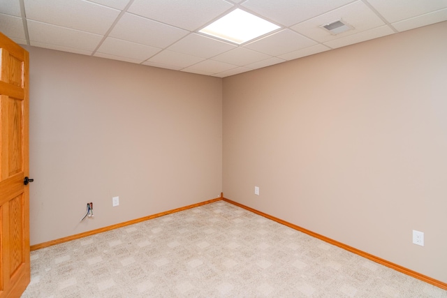 spare room with baseboards, visible vents, and a drop ceiling