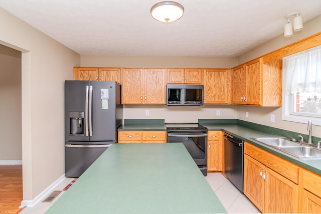 kitchen featuring dark countertops, visible vents, stainless steel appliances, and a sink