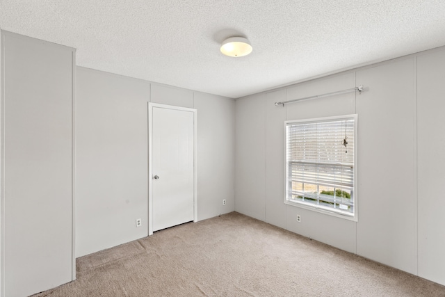 carpeted spare room with a textured ceiling