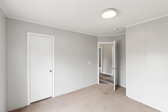 unfurnished bedroom featuring ornamental molding and carpet flooring