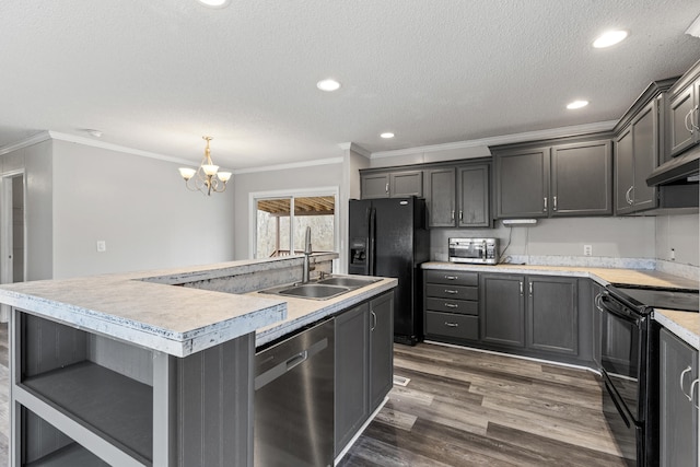 kitchen featuring sink, dark wood-type flooring, a kitchen island with sink, black appliances, and decorative light fixtures