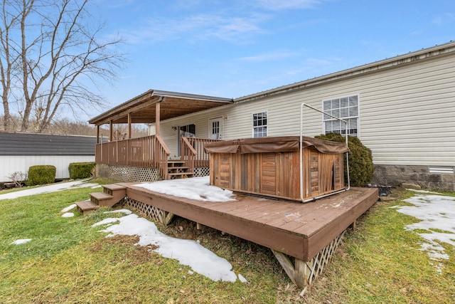 deck featuring a hot tub and a yard