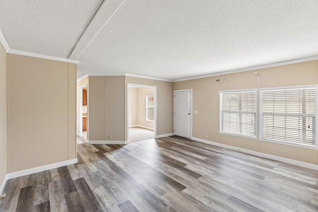 empty room featuring ornamental molding, hardwood / wood-style floors, and a textured ceiling