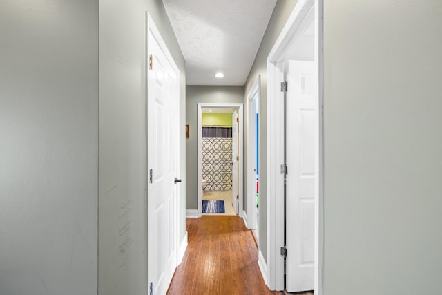 corridor featuring hardwood / wood-style floors and a textured ceiling