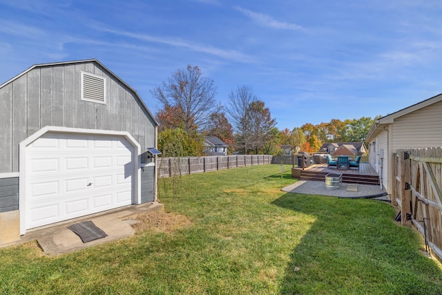 view of yard with a wooden deck, a garage, and an outdoor structure