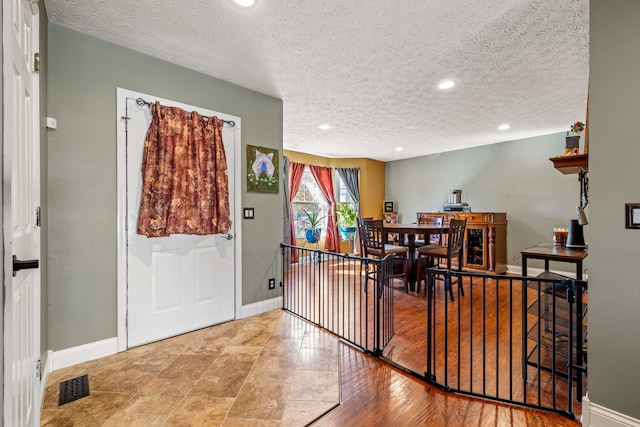 dining area with wood-type flooring and a textured ceiling