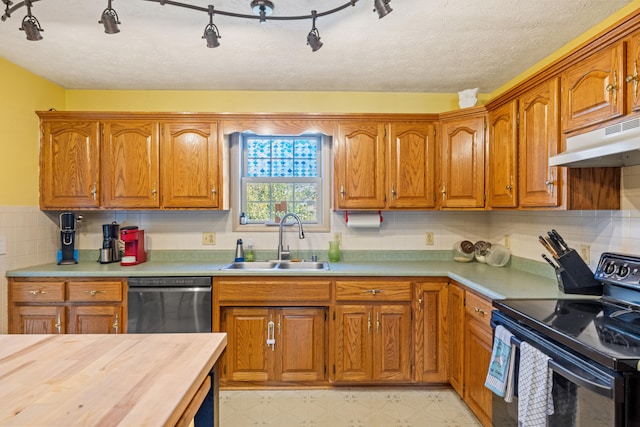 kitchen featuring sink, backsplash, black appliances, a textured ceiling, and wood counters