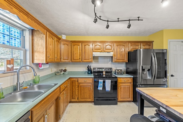 kitchen with stainless steel appliances, sink, a textured ceiling, and backsplash