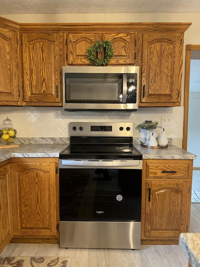 kitchen featuring tasteful backsplash, appliances with stainless steel finishes, and a textured ceiling