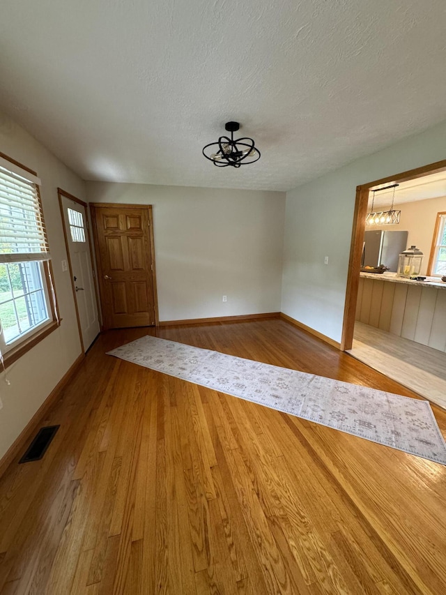 foyer entrance featuring hardwood / wood-style flooring and a textured ceiling