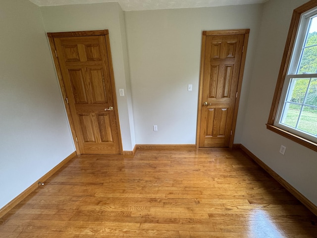 empty room with light hardwood / wood-style flooring