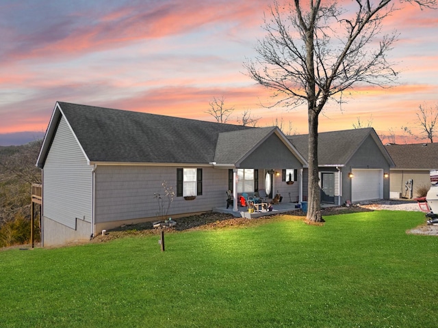 view of front of property with a garage, a yard, and a patio area