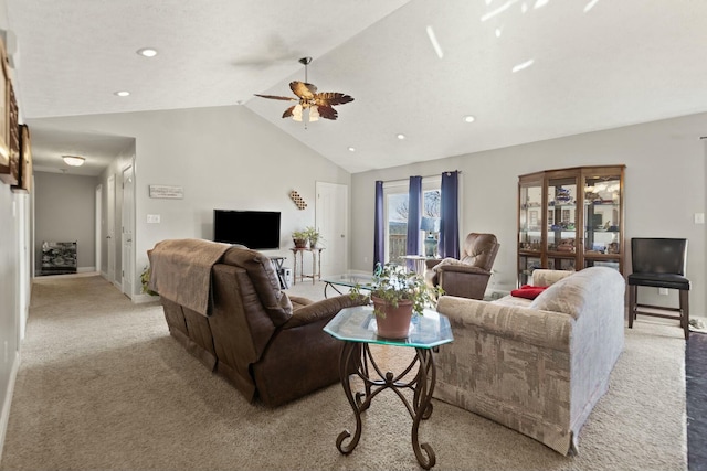 carpeted living room with ceiling fan and vaulted ceiling