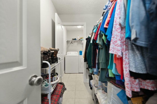 spacious closet featuring washing machine and dryer and light tile patterned floors