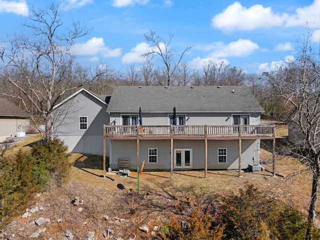 rear view of house featuring cooling unit, a wooden deck, and french doors