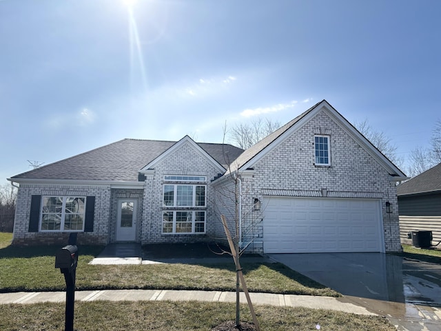 view of property featuring central AC unit, a garage, and a front yard